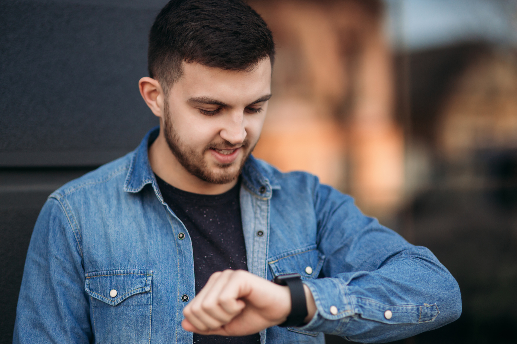 Man Checking Smart Watch while on the Street